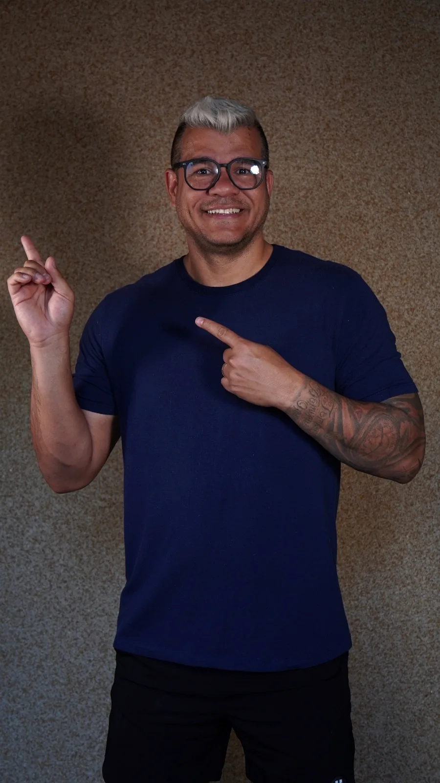 Professor Valdoeste sorrindo e indicando o caminho ao lado